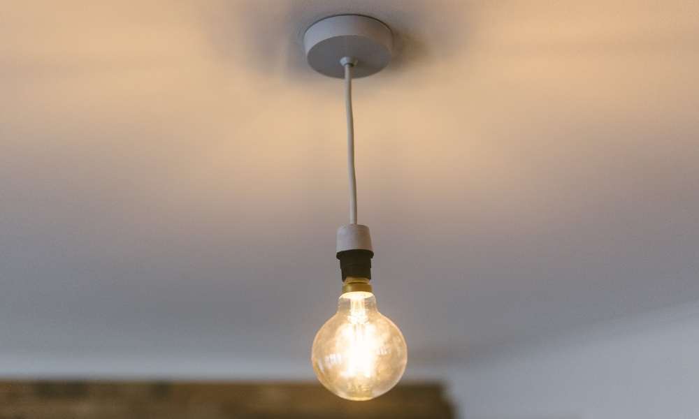 Using a power drill, screw in the light bulbs